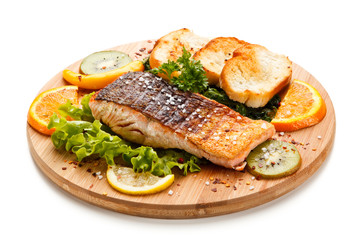 Grilled salmon with bread on wooden board on white background 
