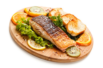 Grilled salmon with bread on wooden board on white background 