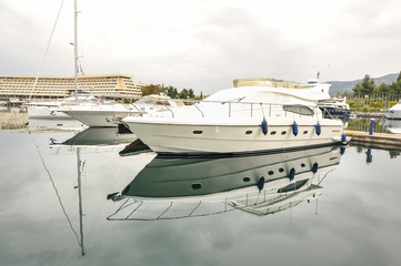 Fototapeta premium Yachts anchored at the marina.Sailboat harbor, many moored sail yachts in the sea port, modern water transport,summertime vacation, luxury lifestyle and wealth concept.Modern yachts in harbor