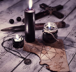 Still life with three black candles, old paper with pentagram and cross. Vampire killer concept