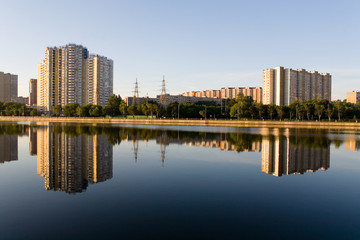 The residential complex is reflected in the Moscow River at dawn.