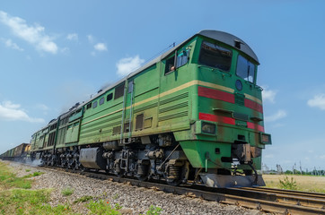 Fototapeta na wymiar green locomotive in motion on the railway