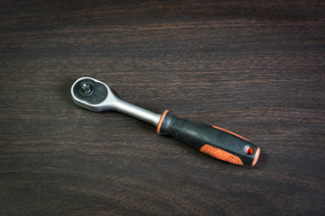 ratchet wrench lying on wooden table