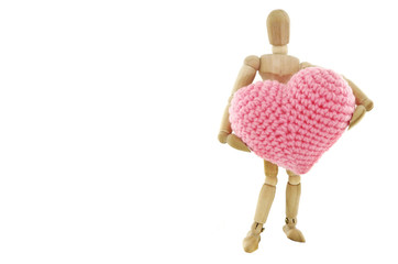 Wooden mannequin holding heart knit with yarn