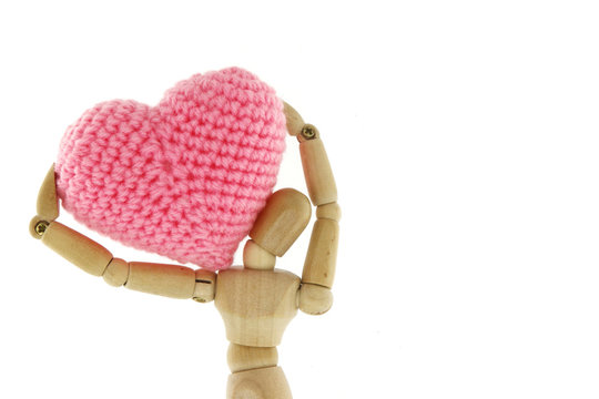 Wooden mannequin carry heart knit with yarn on the shoulder