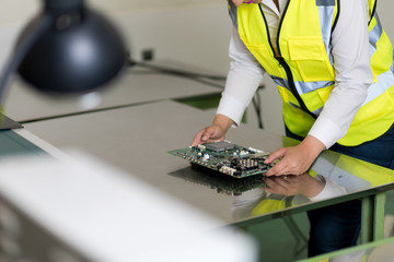 woman worker checking a electric circuit board.