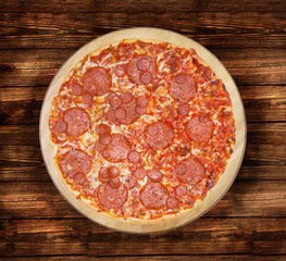 Salami pizza on the  wooden table. This picture is perfect for you to design your restaurant menus. Visit my page. You will be able to find an image for every pizza sold in your cafe or restaurant. 