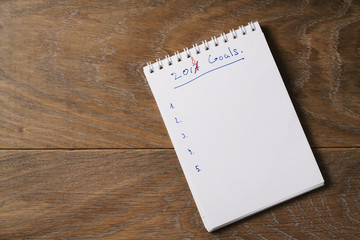 2018 goals list on notepad on wood background