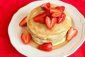 Pancakes with strawberry on a white wooden table. Selective focus.