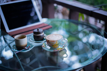Cup of hot drink with coffee on table.