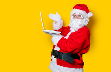 Fototapeta na wymiar Funny Santa Claus have a fun with laptop