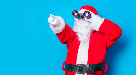 Naklejka premium Funny Santa Claus have a fun with binoculars