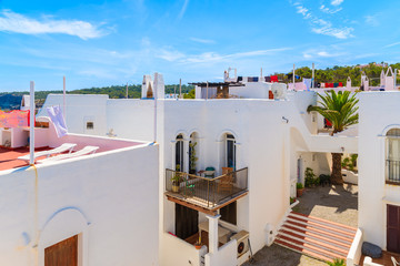 White houses with laundry drying on roofs in Cala Portinatx bay, Ibiza island, Spain