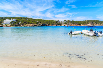 Fototapeta na wymiar Dinghy motor boats in water on Cala Portinatx beach, Ibiza island, Spain