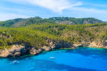 Obraz na płótnie Canvas Sailing boats on azure blue sea on northern coast of Ibiza island between Cala Xarraca bay and Cala Benirras bay, Spain.