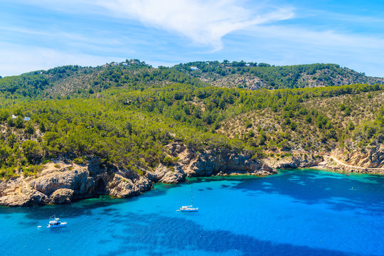 Sailing boats on azure blue sea on northern coast of Ibiza island between Cala Xarraca bay and Cala Benirras bay, Spain.