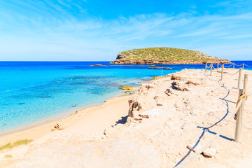 Coastal path along beautiful Cala Comte beach famous for its azure crystal clear shallow sea water, Ibiza island, Spain
