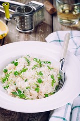 Homemade risotto with chicken, green peas, arugula and parmesan