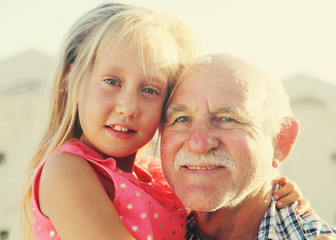 grandfather holding 6 years old granddaughter