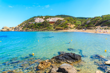 View of Es Figueral beach and hotel building on green hill, Ibiza island, Spain