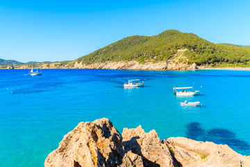 Obraz premium Fishing boats on blue sea water of Cala San Vicente bay, Ibiza island, Spain