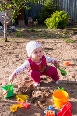 Child of year and half plays in sandbox