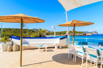White skull of a fishing boat on sunny restaurant terrace on Cala Nova beach, Ibiza island, Spain.