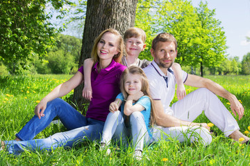 Naklejka na ściany i meble Family on grass in summer park