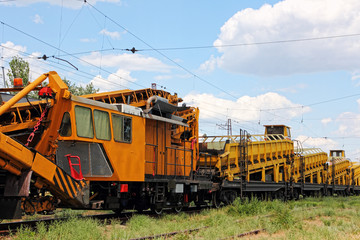 Orange Railway track service car.Crushed stone install construction machine.