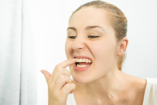 Portrait Of Woman Picking Food Stuck In Teeth With Finger