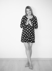 Black and white image of cute pregnant woman posing with lollipop