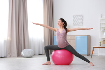 Beautiful pregnant woman doing exercise at home