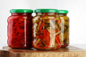 Jar with variety of pickled vegetables. Carrots, field garlic, cucumber in glas. Preserved food