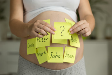 Conceptual image of pregnant woman choosing future baby name