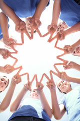 Team of volunteers putting their hands together as symbol of unity, bottom view