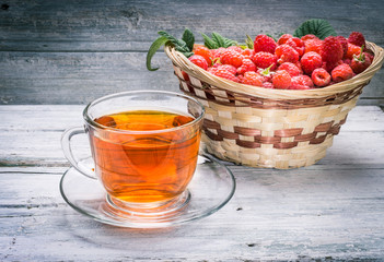 Cup of tea and basket with raspberry