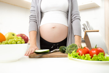 Fototapeta na wymiar Young pregnant woman standing on kitchen