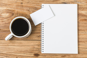 Blank business cards and cup of coffee on wooden table. Corporate stationary branding mock up.