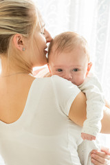 Portrait of young loving mother holding her baby boy