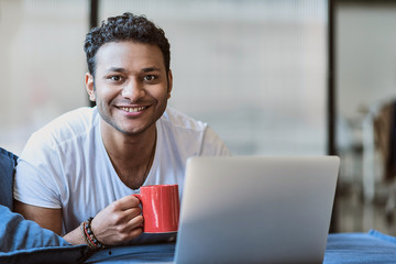 Happy young man relaxing during work on laptop