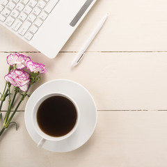 Office table with cup of coffee and flowers 