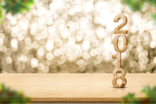 Happy new year 2018 on wood table and blur Christmas tree foreground at blur sparkling gold bokeh light wall,panoramic banner for display or montage of product,holiday seasonal
