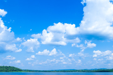 The beautiful white clouds form a distinct shape and the bottom is a forest. Wide view.