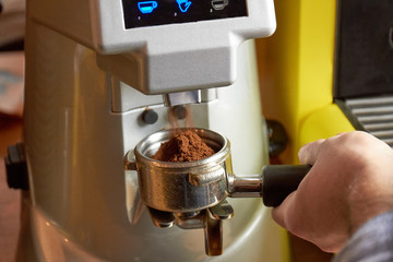 Male hand and coffee machine. Portafilter close up. Tips for new baristas.