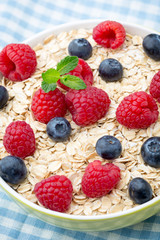 Oatmeal porridge with berries. Raspberries and blueberries.