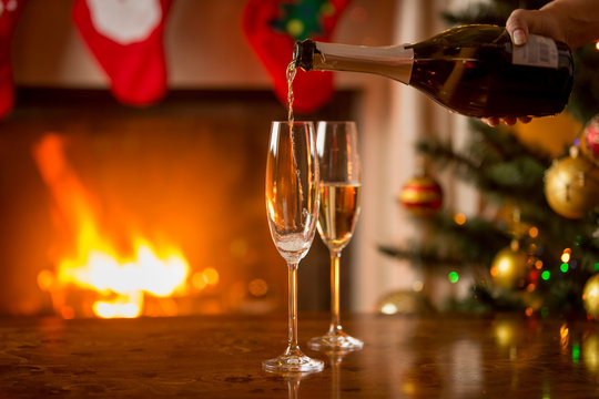 Closeup of two glasses of champagne next to the fireplace