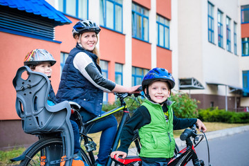 Family cycling, mother with happy kid riding bike outdoors