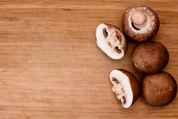 Gray mushrooms champignons lie on a wooden kitchen board