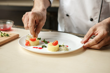  Mature man professional chef cooking meal indoors