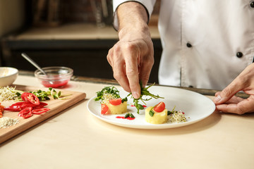  Mature man professional chef cooking meal indoors